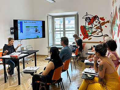 Moderner Klassenraum mit kreativer Wandgestaltung – Italienisch-Unterricht mit internationalen Teilnehmern.