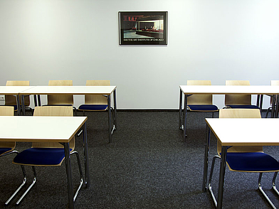 Helles Klassenzimmer mit weißen Tischen und großen Fenstern für Deutschunterricht in Hamburg