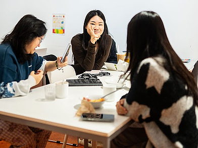 Gruppe von Schülerinnen sitzt entspannt am Tisch und unterhält sich in der Freizeit während der Oxford Schüler Sprachreise.