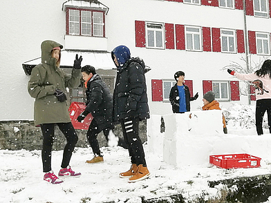 Schüler beim Schneeballspielen vor dem Humboldt-Institut Lindenberg im Winter