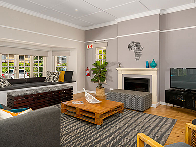 Espace commun confortable avec canapé, cheminée et télévision pour les étudiants en langues