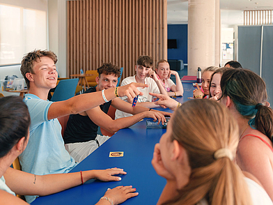 chülergruppe bei einem Gemeinschaftsspiel im Aufenthaltsbereich der Expanish Sprachschule Barcelona während der Spanisch Sprachreise.