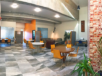 Großzügiger Gemeinschaftsraum der Nelson English Centre Sprachschule, ausgestattet mit Tischen, Sofas und viel Platz für Austausch.