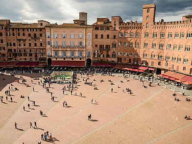Blick auf die berühmte Piazza del Campo in Siena mit ihren historischen Gebäuden und vielen Menschen – zentraler Treffpunkt und kulturelles Highlight während einer Sprachreise nach Italien.