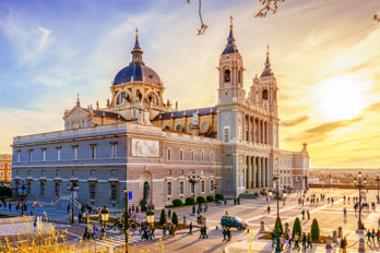 Panoramablick auf die Kathedrale Almudena und den Königspalast in Madrid bei Sonnenuntergang während einer Sprachreise in Spanien.